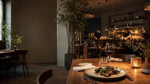 Gedeckter Restauranttisch mit Weinglas und Kerze am Abend